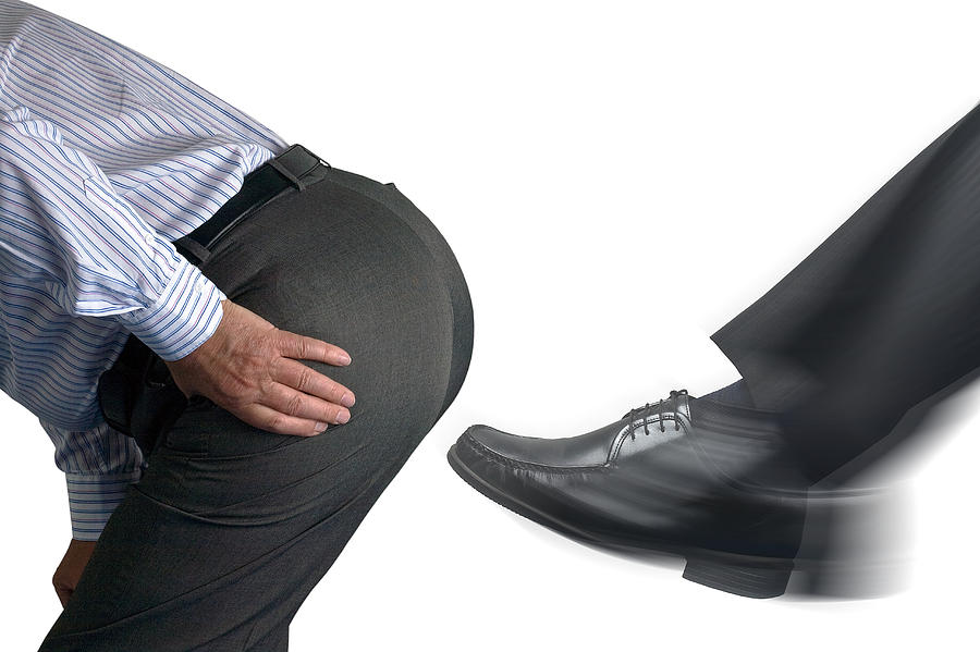 Businessman getting a kick up the backside Photograph by GSO Images