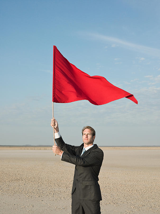 Businessman holding a red flag Photograph by Image Source
