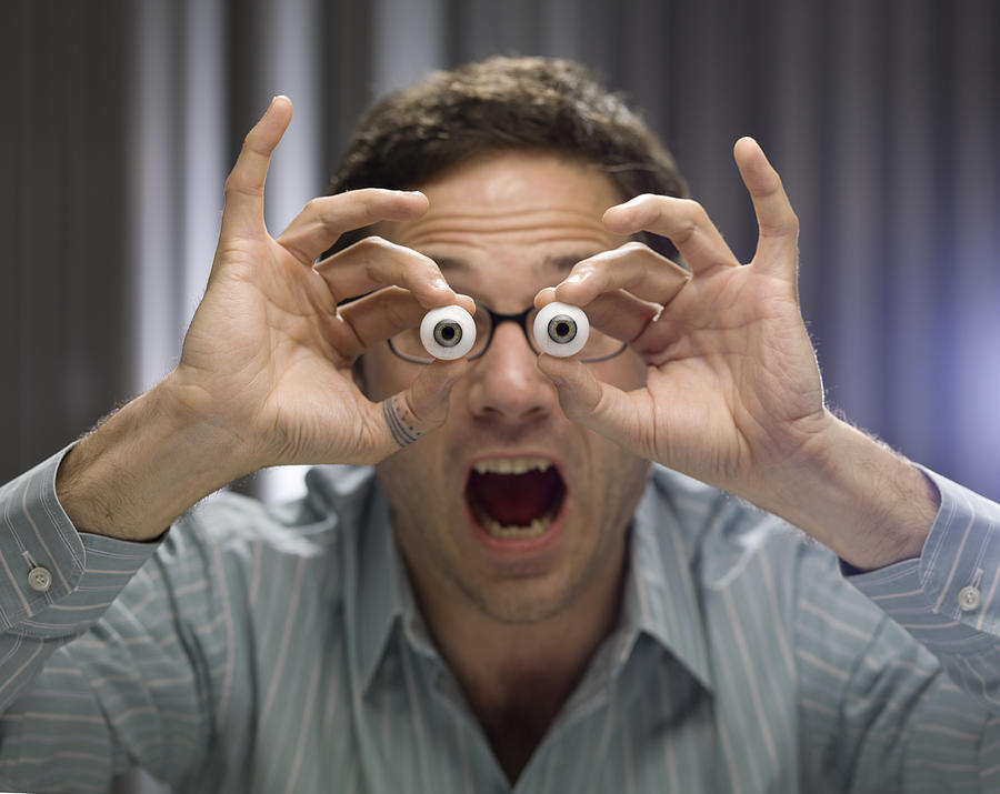 Businessman holding glass eyes Photograph by Colin Hawkins