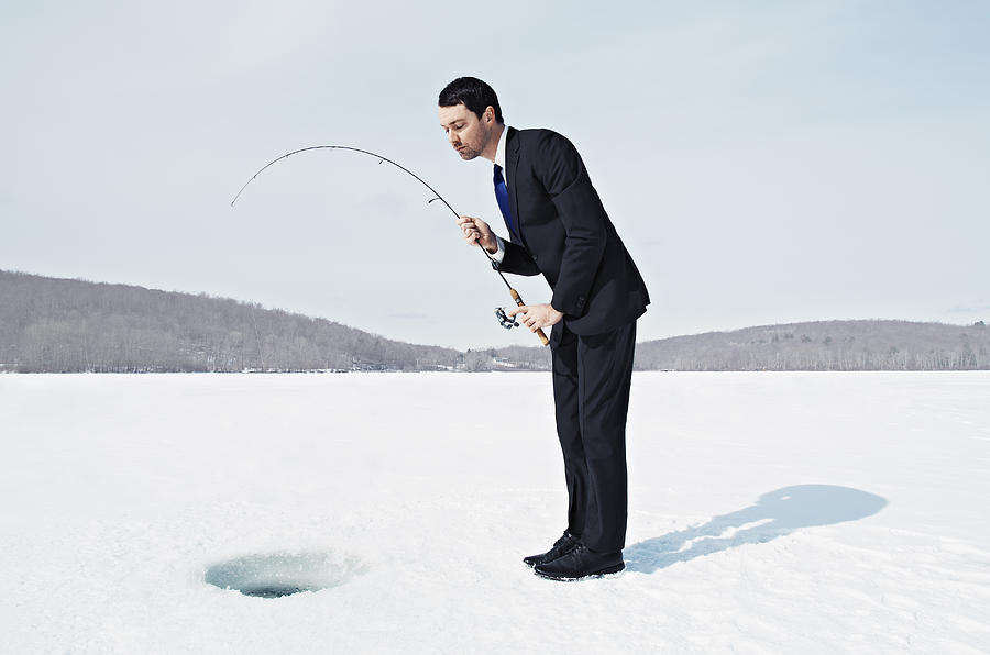 Businessman Ice Fishing on Frozen Lake. Photograph by Andy Ryan
