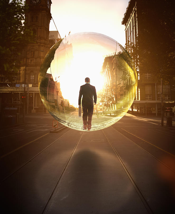 Businessman in bubble walking on city street Photograph by Colin Anderson Productions pty ltd
