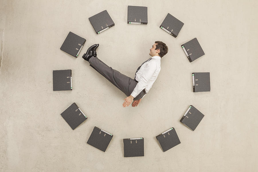 Businessman inside circle of files forming clock Photograph by Westend61