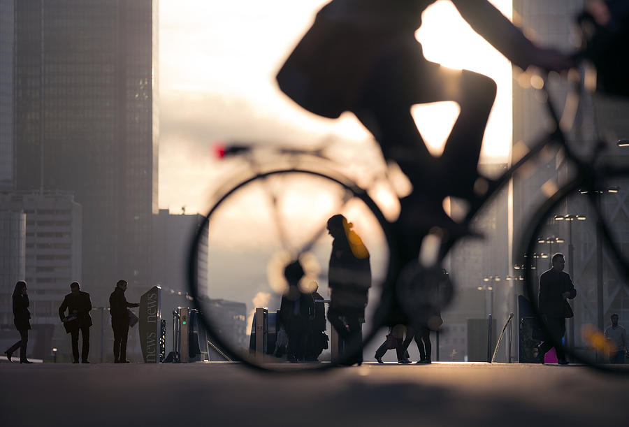 Businessman on bicycle passing skyline La Defense Photograph by EschCollection