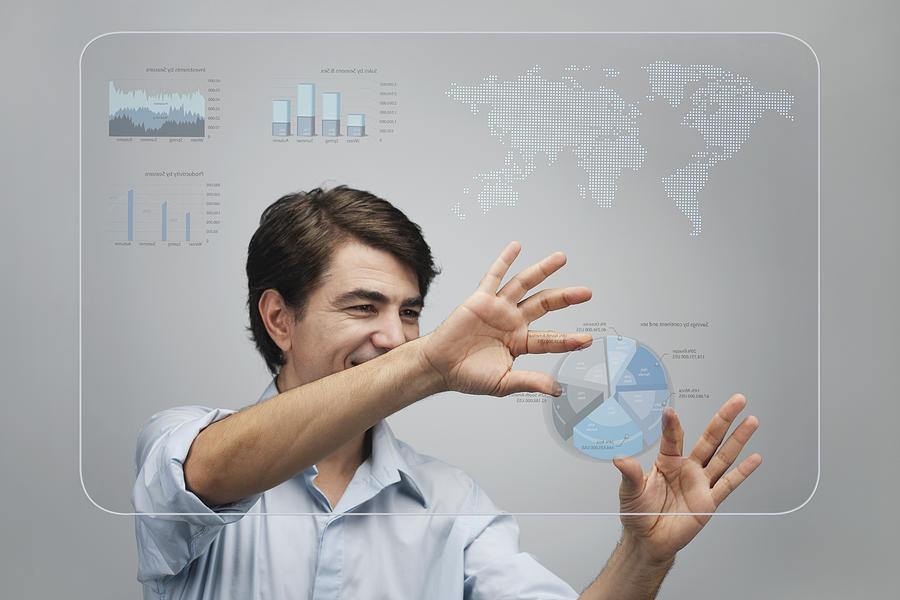 Businessman using advanced touch screen technology to view sales data Photograph by PhotoAlto/Milena Boniek