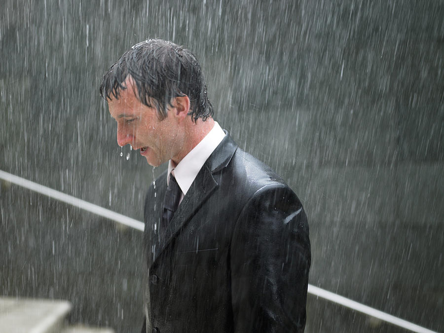 Businessman walking up steps in rain, profile, close-up Photograph by Michael Blann