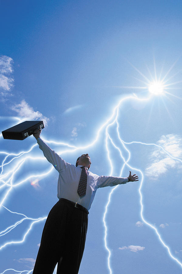 Businessman with arms raised and lightning bolts Photograph by Comstock
