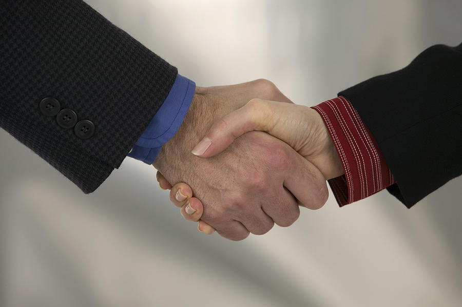 Businesspeople shaking hands Photograph by Comstock Images