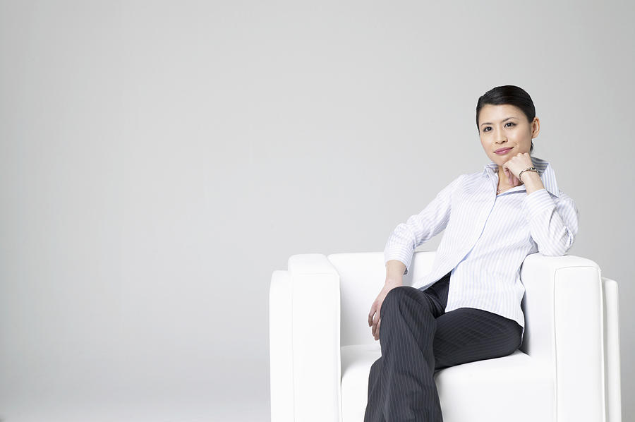 Businesswoman Sitting in an Armchair With Her Hand on Her Chin Photograph by Mash