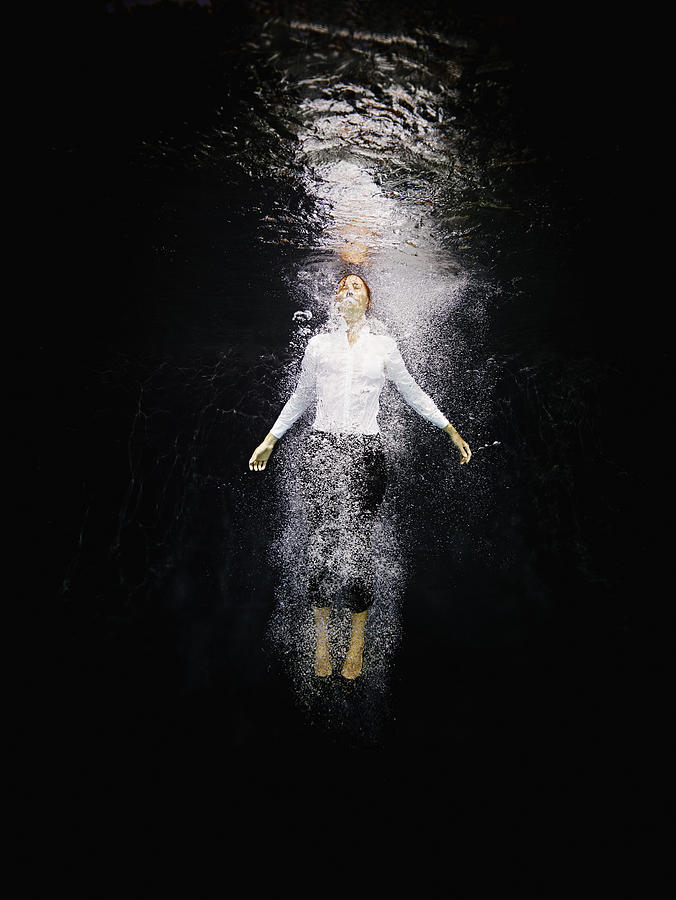 Businesswoman underwater amid air bubbles Photograph by Thomas Barwick