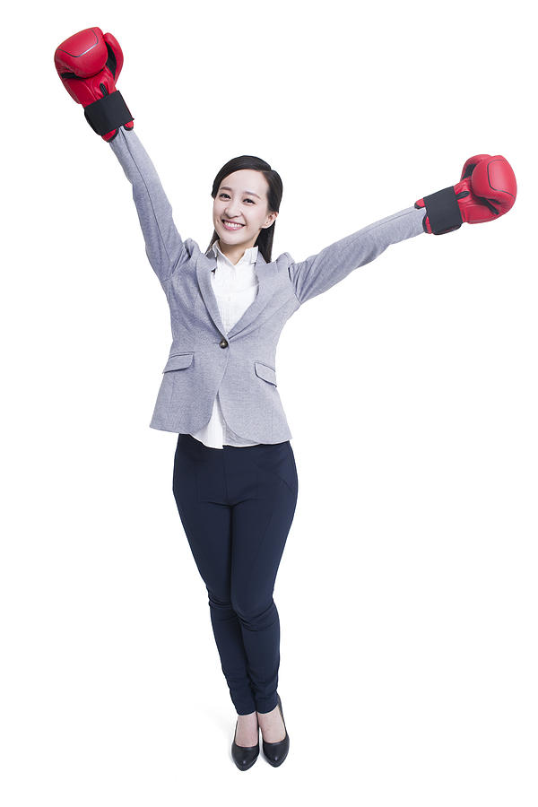 Businesswoman with boxing gloves celebrating victory Photograph by BJI / Blue Jean Images