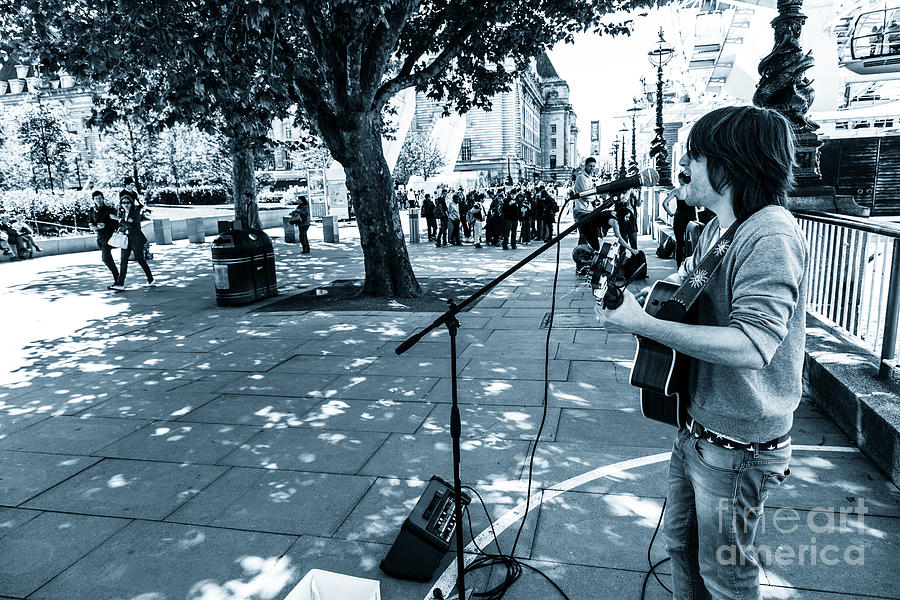 Busker playing acoustic guitar on the London embankment Photograph by Peter Noyce
