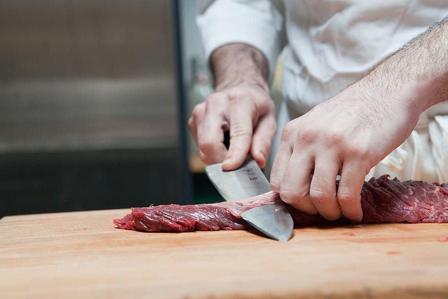 Butcher preparing beef tenderloin Photograph by Image Source