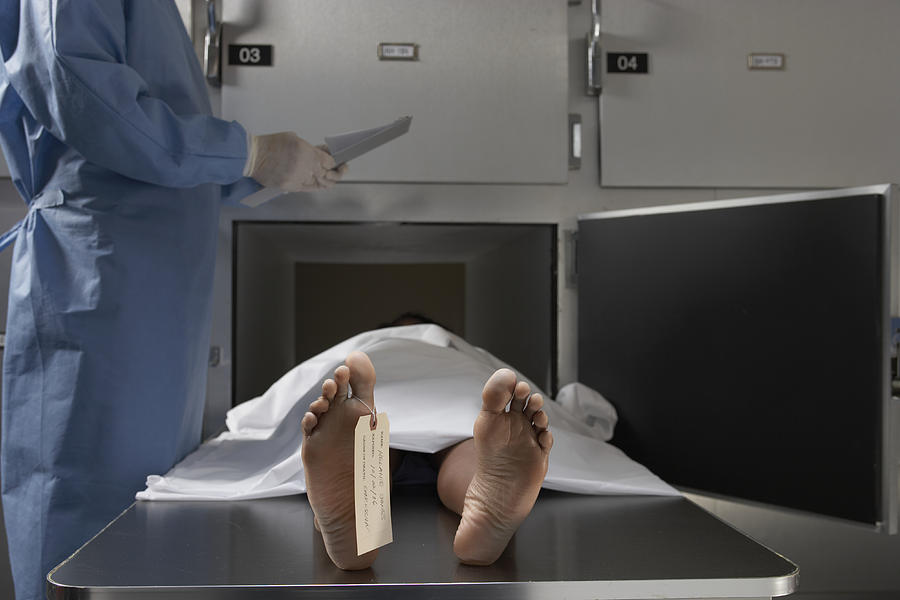 Cadaver on autopsy table, label tied to toe, close-up Photograph by Darrin Klimek