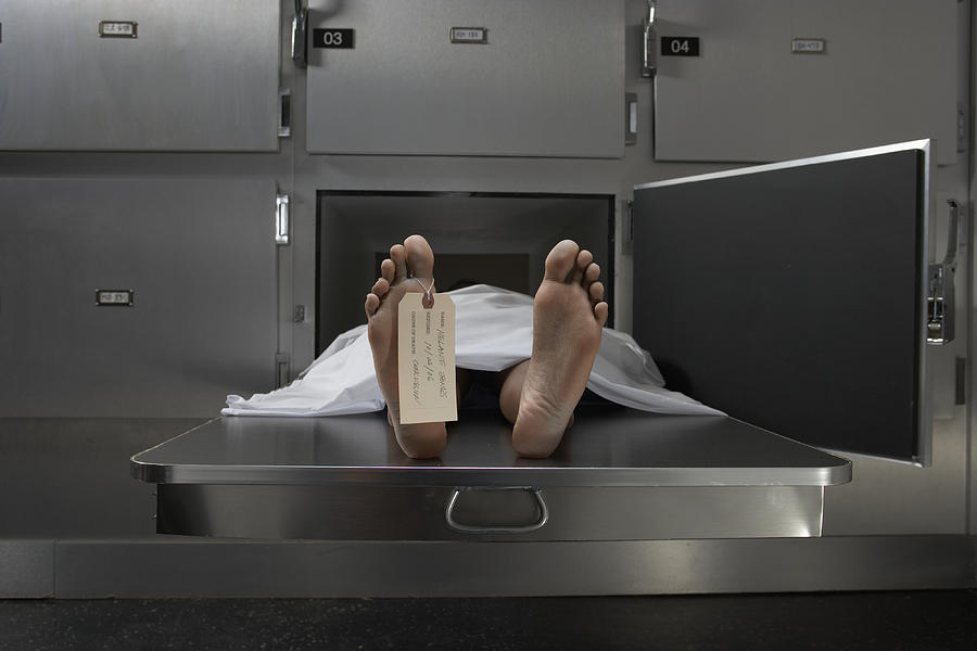 Cadaver on autopsy table, label tied to toe Photograph by Darrin Klimek