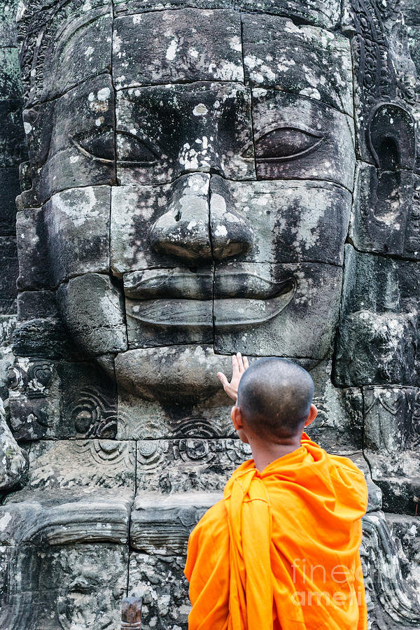 Cambodia - Angkor Wat - Monk touching giant Buddha statue Photograph by Matteo Colombo