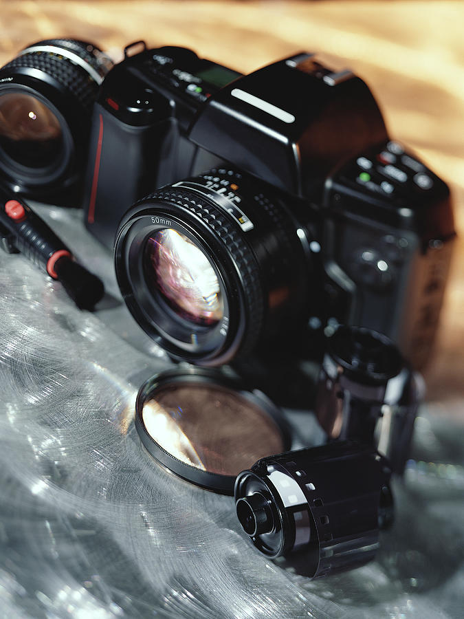 Camera, lenses, and film canister Photograph by Stockbyte