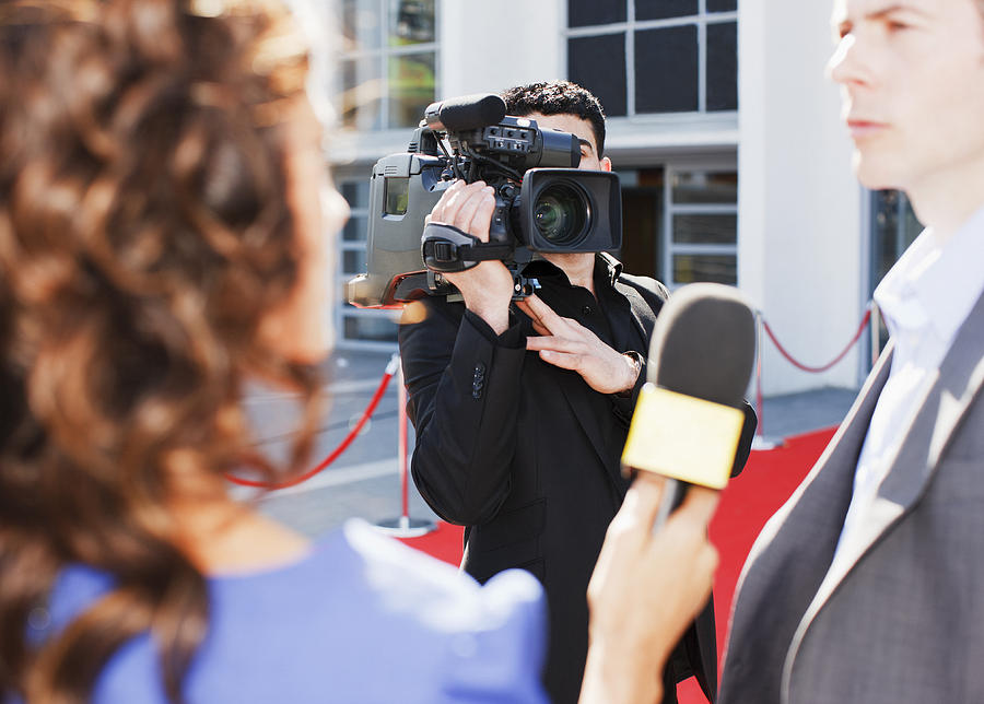 Cameraman taping celebrity on red carpet Photograph by Paul Bradbury