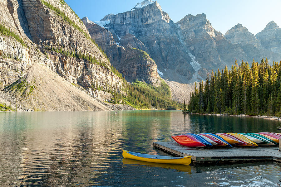 Canoes On Moraine Lake Located In Banff Alberta Photograph by Art Calapatia