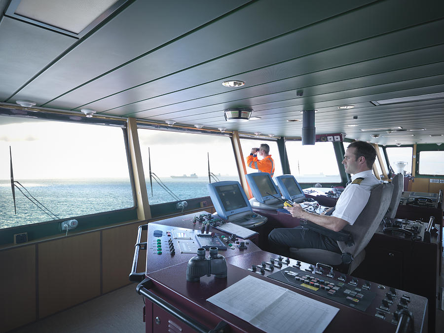 Captain and worker on bridge steering ship at sea Photograph by Monty Rakusen