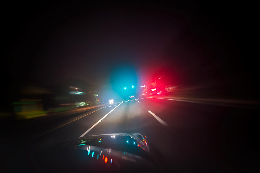 Car driving down road with red and blue lights Photograph by Hillary Kladke