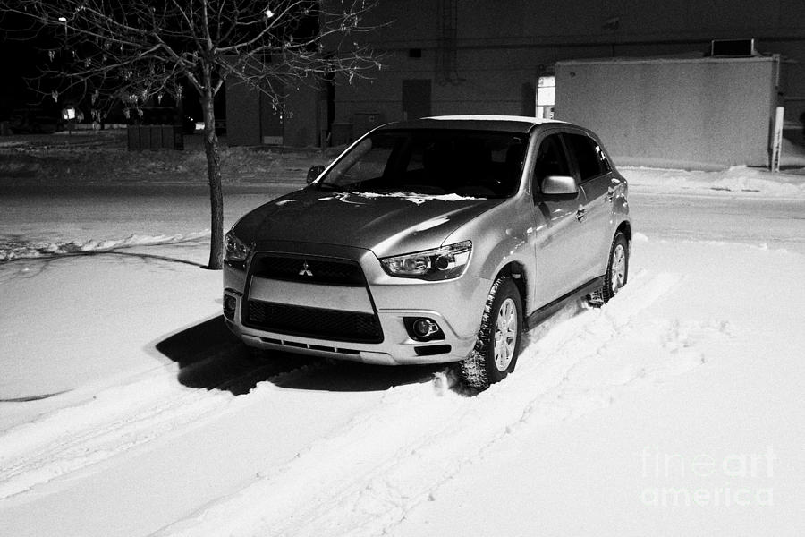 car parked in deepening snow in outdoor parking lot in Saskatoon