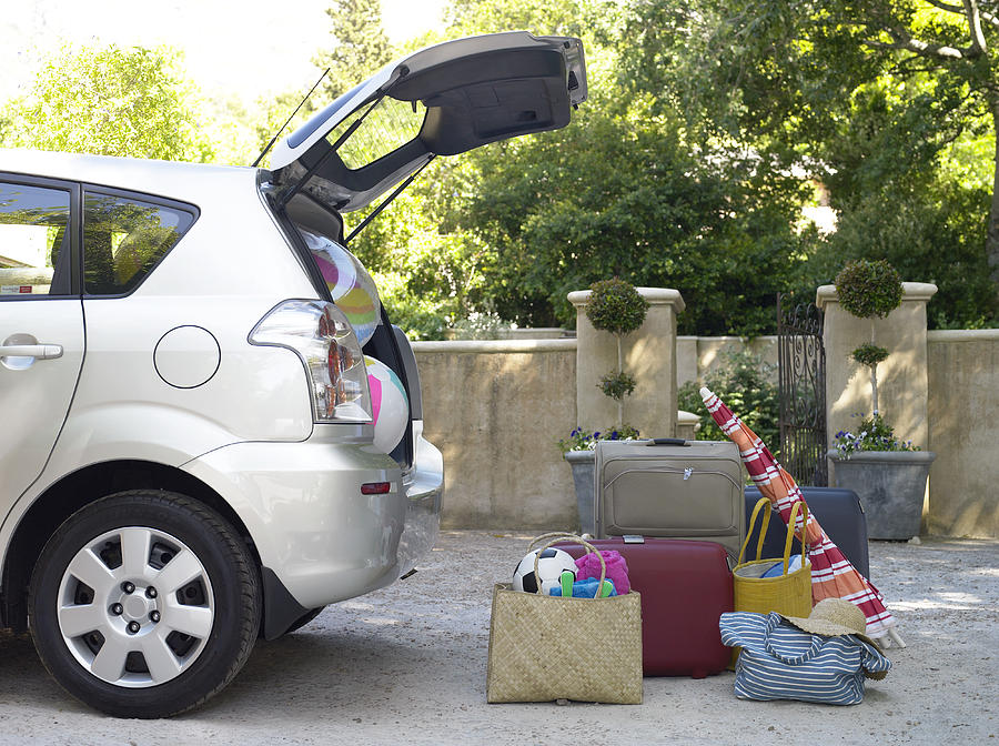 Car with boot open and beach equipment and cases Photograph by Flying Colours Ltd