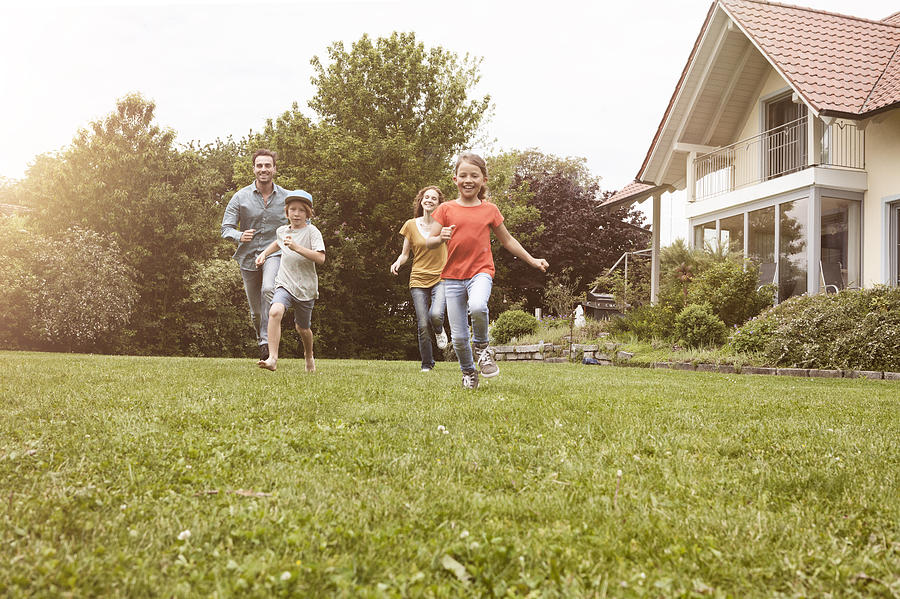 Carefree family running in garden Photograph by Westend61