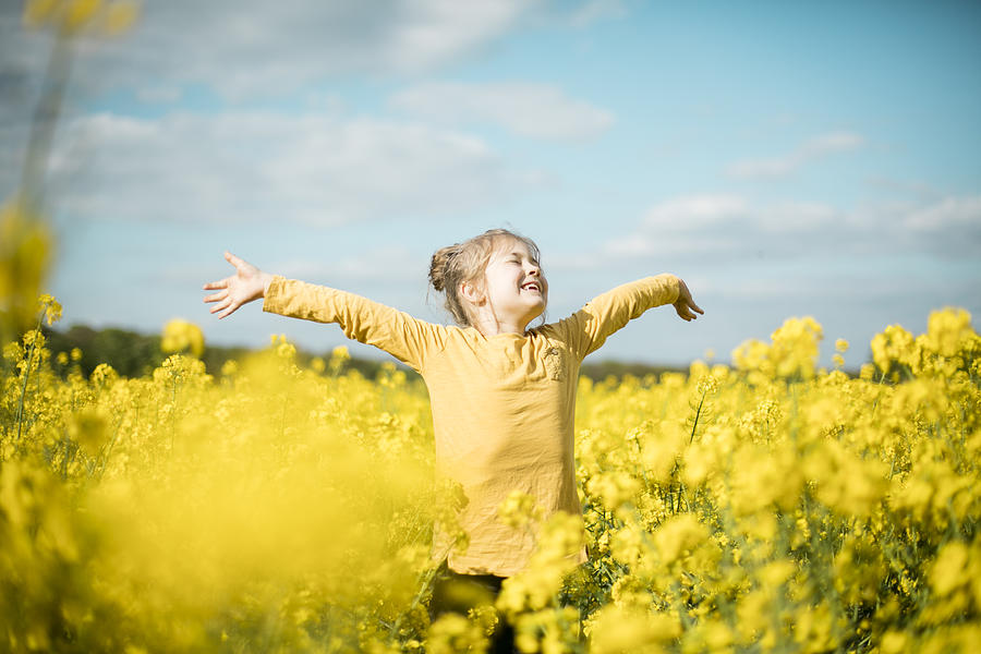 Carefree girl in rape field Photograph by Westend61