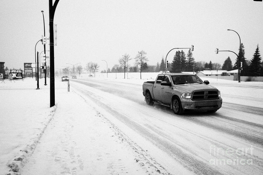 Winter Photograph - cars travelling along 8th street in blizzard conditions Saskatoon Saskatchewan Canada by Joe Fox