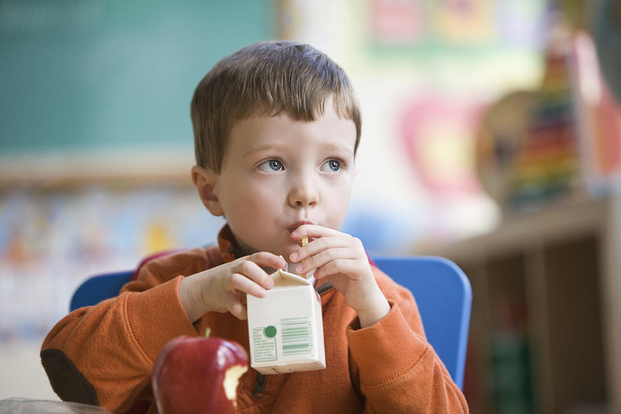 Caucasian boy eating lunch in classroom Photograph by Jose Luis Pelaez Inc