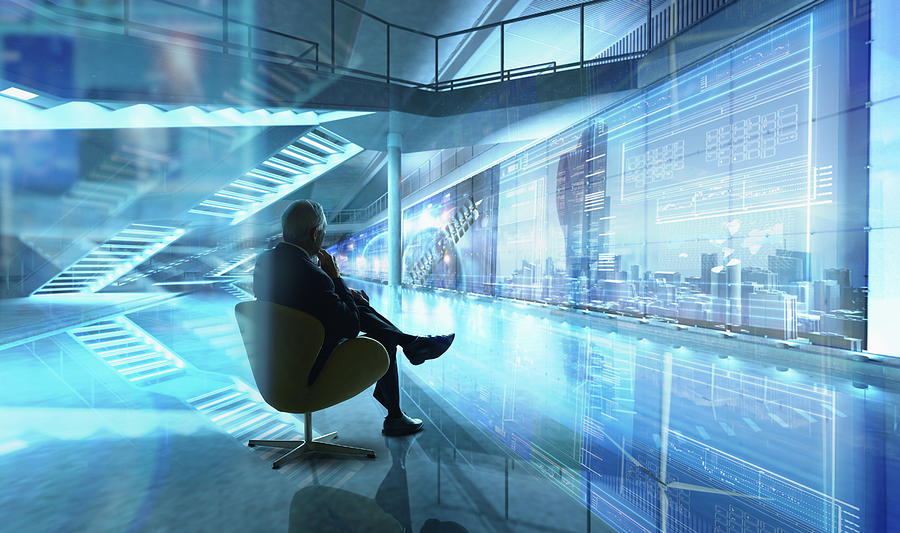 Caucasian businessman sitting in chair in futuristic office Photograph by Colin Anderson Productions pty ltd