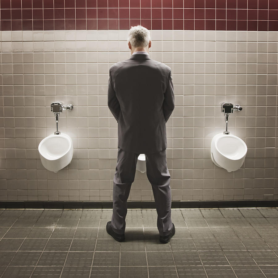 Caucasian businessman using public restroom Photograph by Jetta Productions Inc