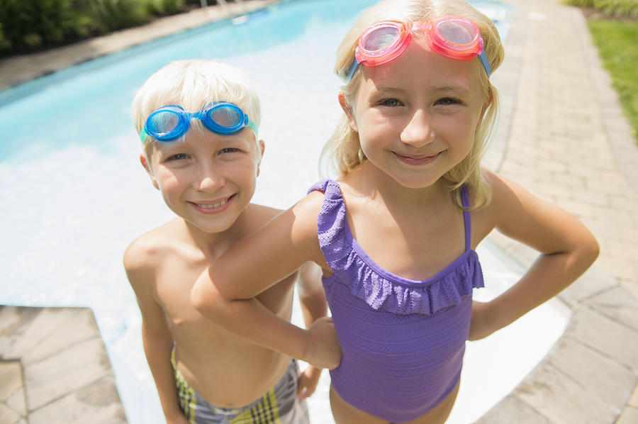 Caucasian children smiling near swimming pool Photograph by JGI/Jamie Grill