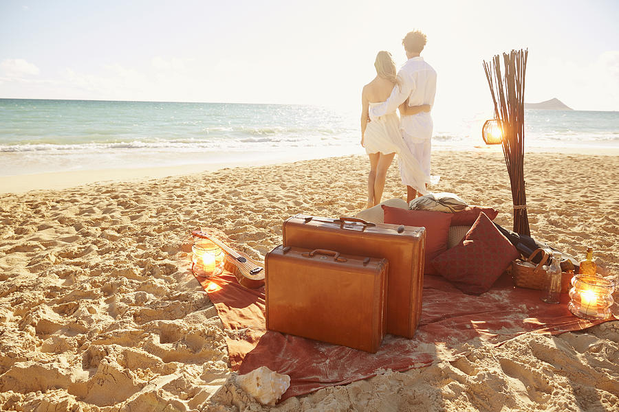 Caucasian couple with suitcases on tropical beach Photograph by Colin Anderson Productions pty ltd