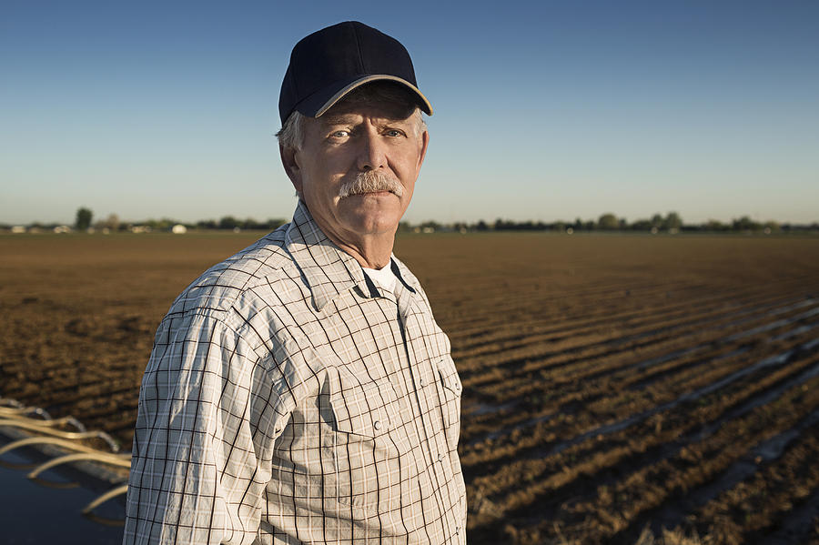 Caucasian farmer standing in irrigated field Photograph by Hill Street Studios