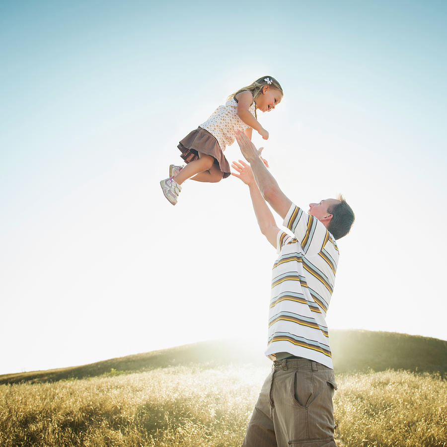 Caucasian Father Lifting Daughter Photograph by Erik Isakson