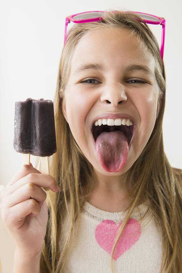 Caucasian girl with stained tongue from grape popsicle Photograph by JGI/Jamie Grill