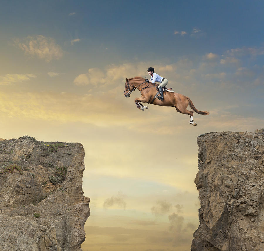 Caucasian jockey jumping canyon on horse Photograph by John M Lund Photography Inc