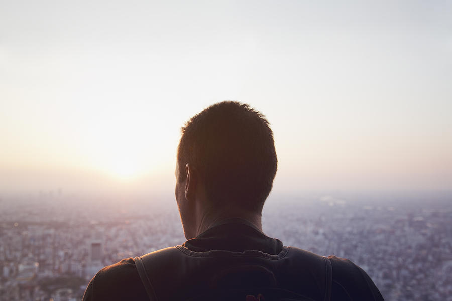 Caucasian man looking down the cityscape of Tokyo Photograph by Kohei Hara