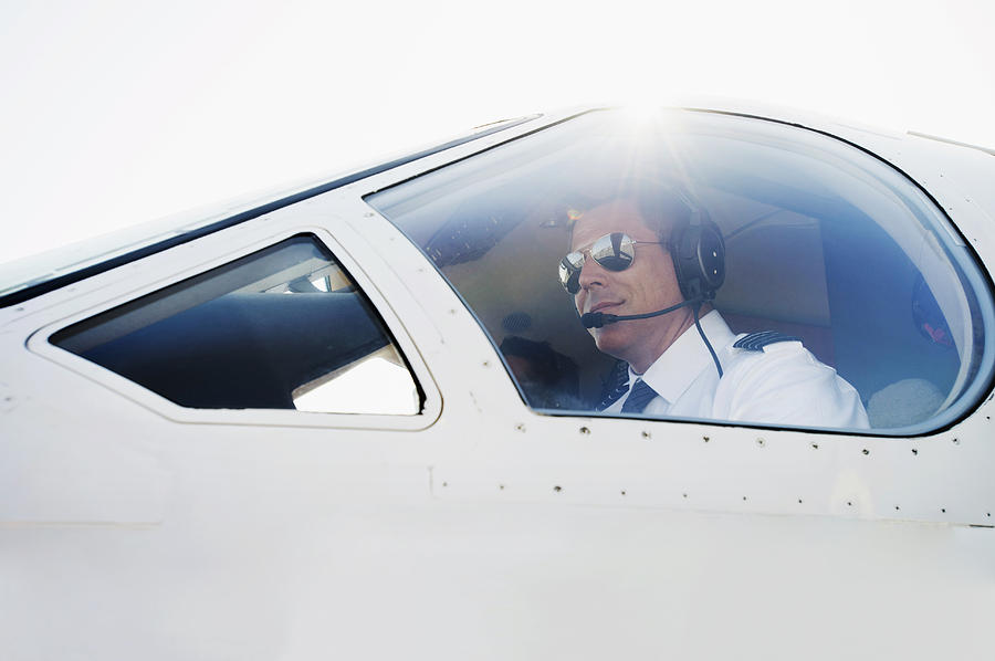 Caucasian pilot in airplane cockpit Photograph by Erik Isakson