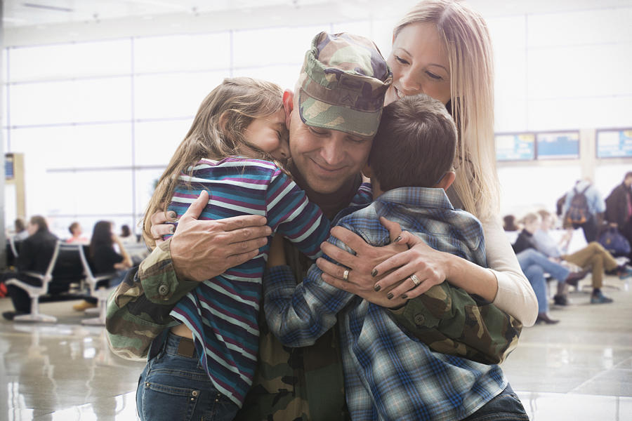 Caucasian returning soldier greeting family Photograph by Jose Luis Pelaez Inc