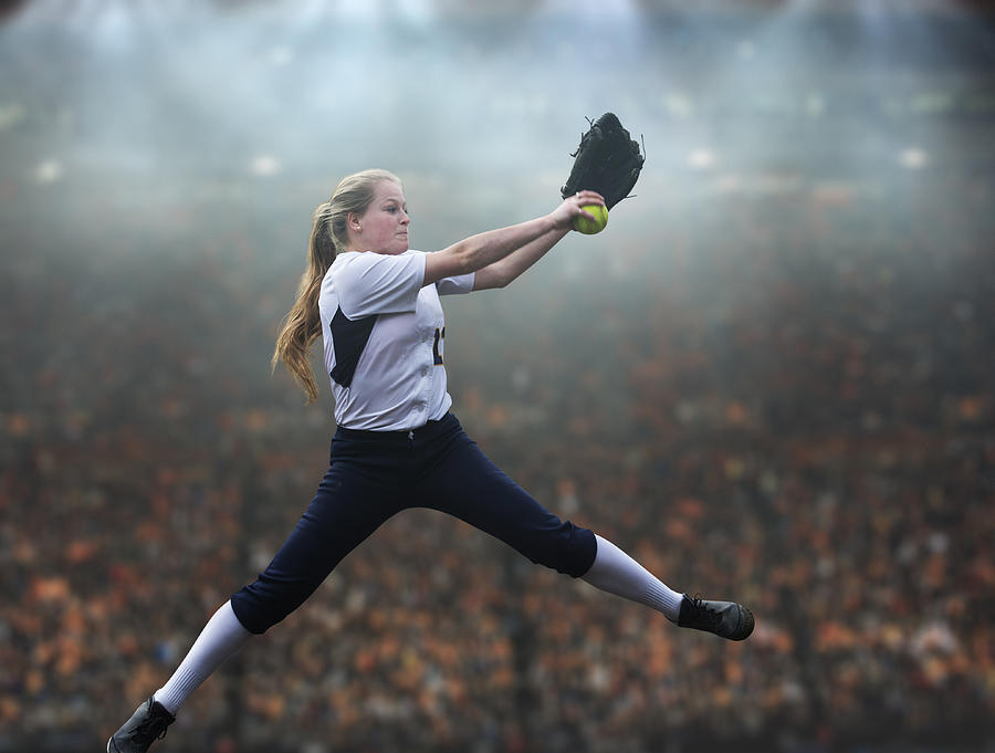 Caucasian softball player pitching ball in stadium Photograph by Pete Saloutos