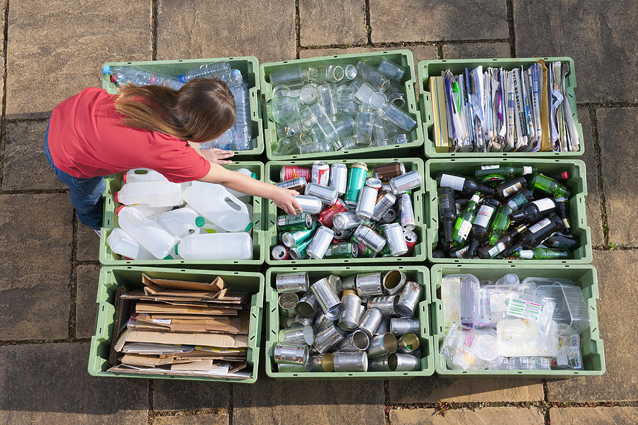 Caucasian teenage girl organizing recycling bins Photograph by Jacobs Stock Photography Ltd