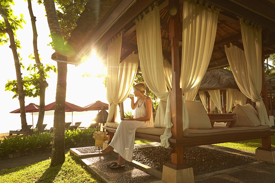 Caucasian woman relaxing in cabana on tropical beach Photograph by Colin Anderson Productions pty ltd