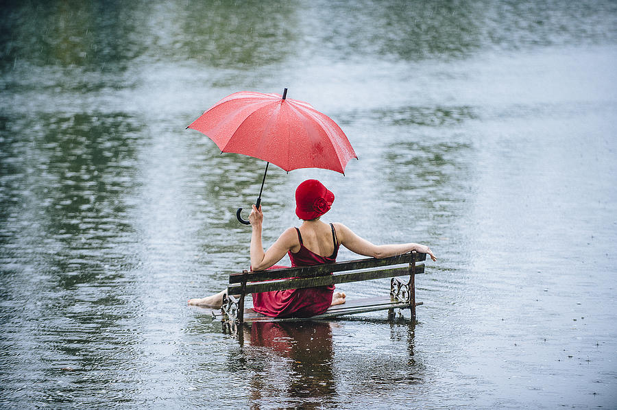 Caucasian woman sitting on bench in flood Photograph by Pete Saloutos