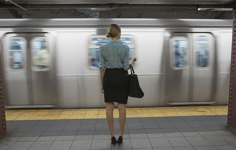Caucasian woman standing near passing subway in train station Photograph by Hello Lovely