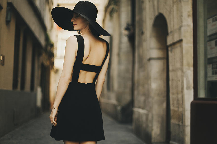 Caucasian woman wearing black dress and sun hat in street Photograph by Sophie Filippova
