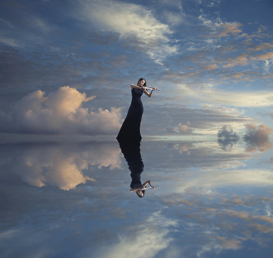 Caucasian woman with violin reflected in still lake Photograph by Colin Anderson Productions pty ltd