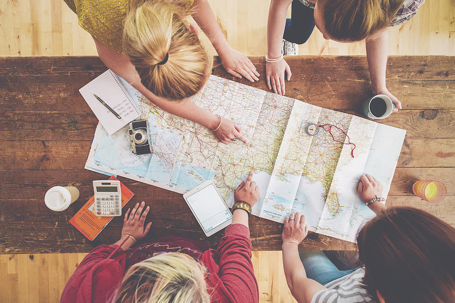 Caucasian women planning trip with map on wooden table Photograph by Jacobs Stock Photography Ltd