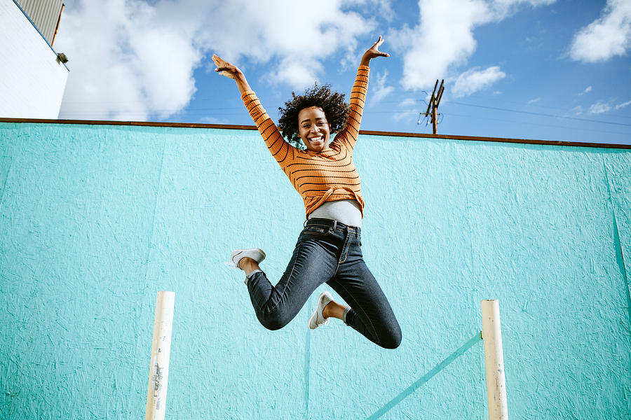 Celebrating Woman Jumps Into The Air Photograph by RyanJLane